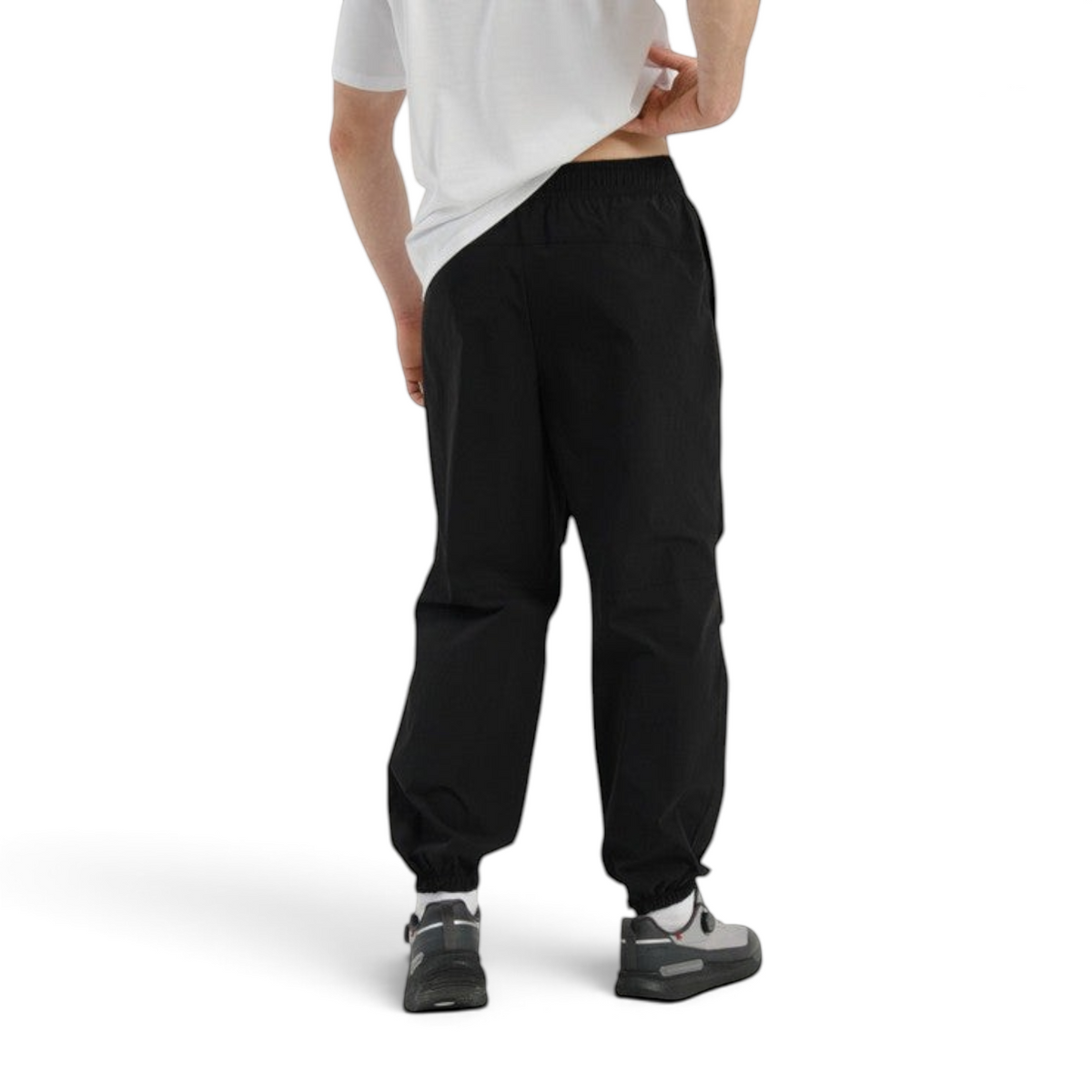 FRG COMMUTE black woven textile trousers with elasticated cuffs worn by a man, back view