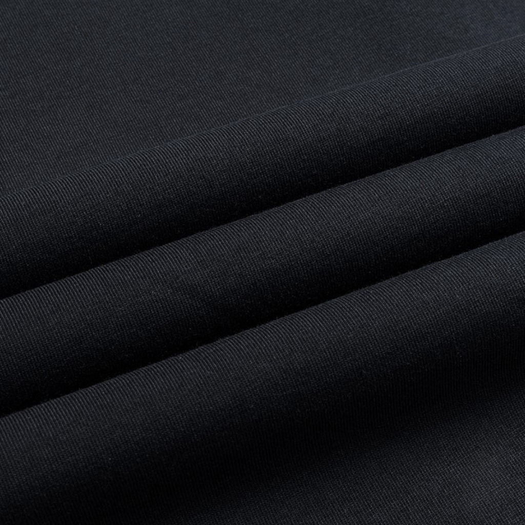 Close-up of the black cotton fabric texture of a FRG SS TEE showing the fine knit detail.