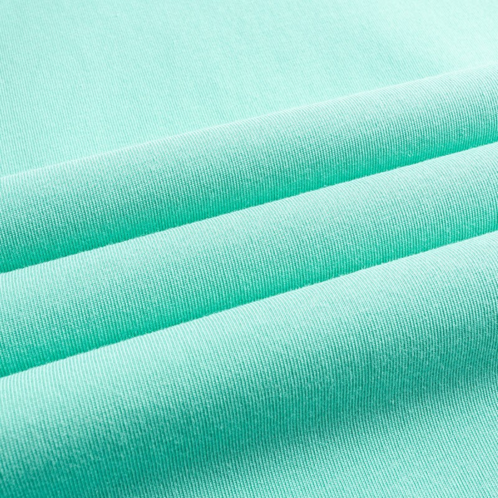 Close-up of soft mint green cotton fabric from a FRG SS TEE showing the smooth texture and draped folds.