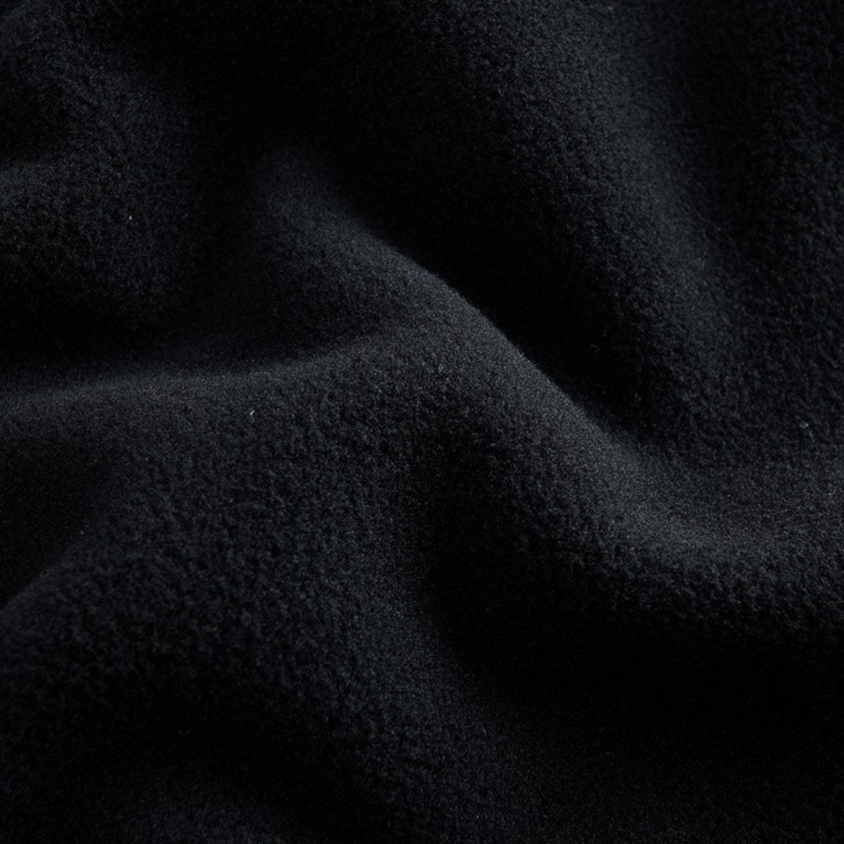 Close-up of soft black knit fabric texture from FRG knit track pants