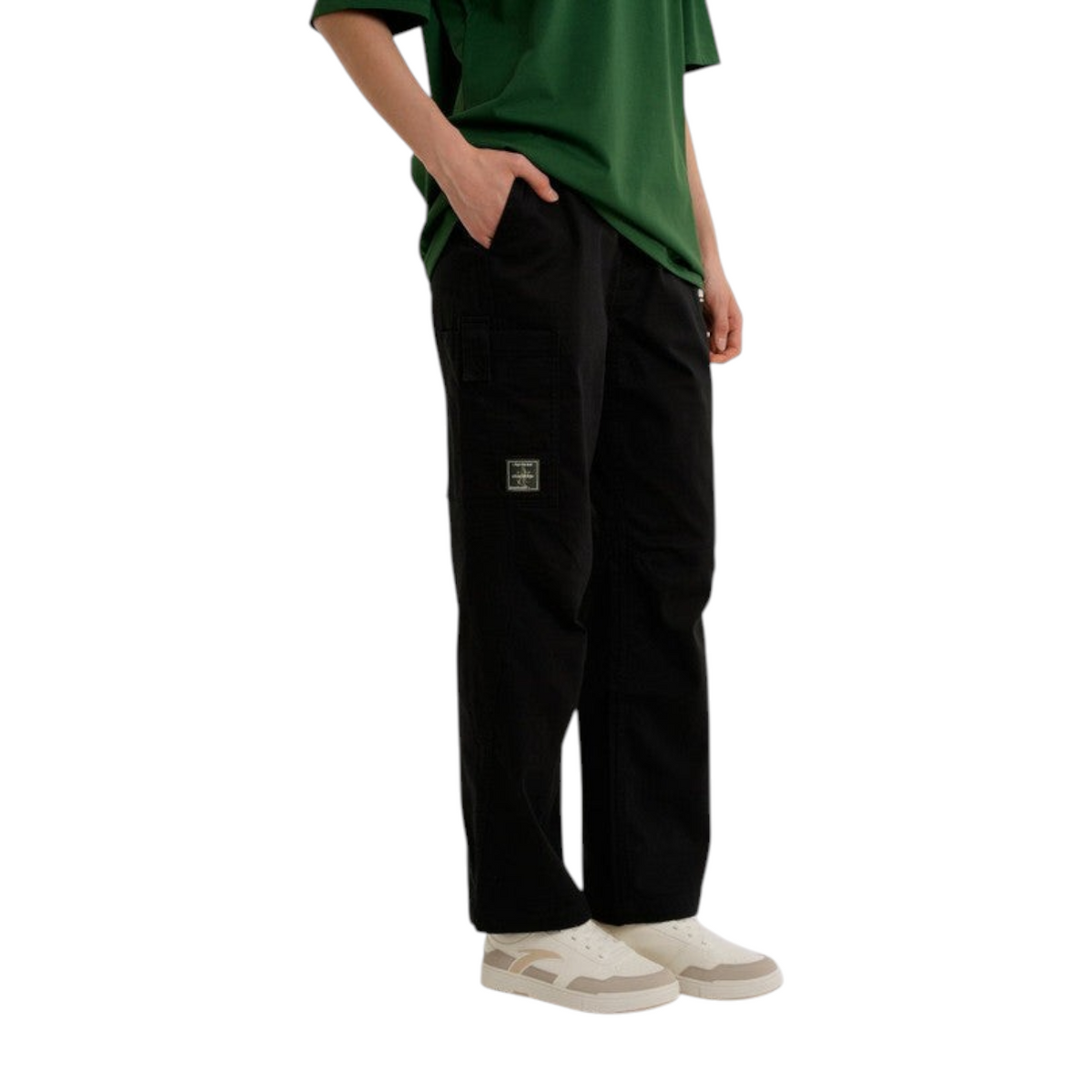 FRG ANTA SKATE black woven casual pants with a relaxed fit and side pocket detail worn with a green t-shirt