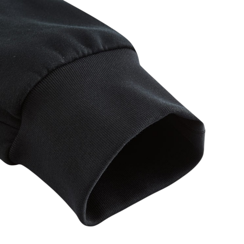 Close-up of the black ribbed elastic cuff on FRG knit track pants