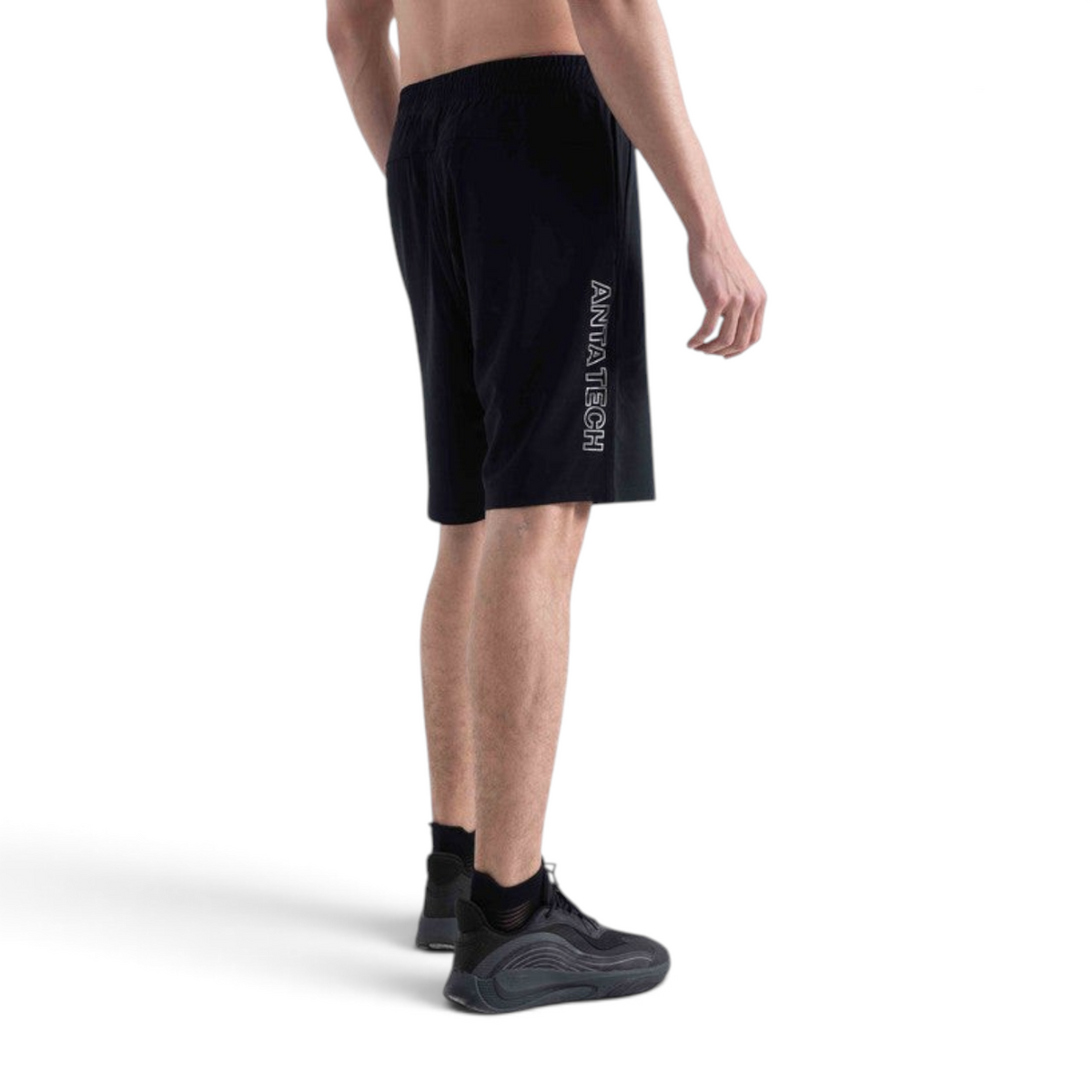 FRG knit half pants in black with ANTA TECH logo on the side, worn by a man with black athletic sneakers