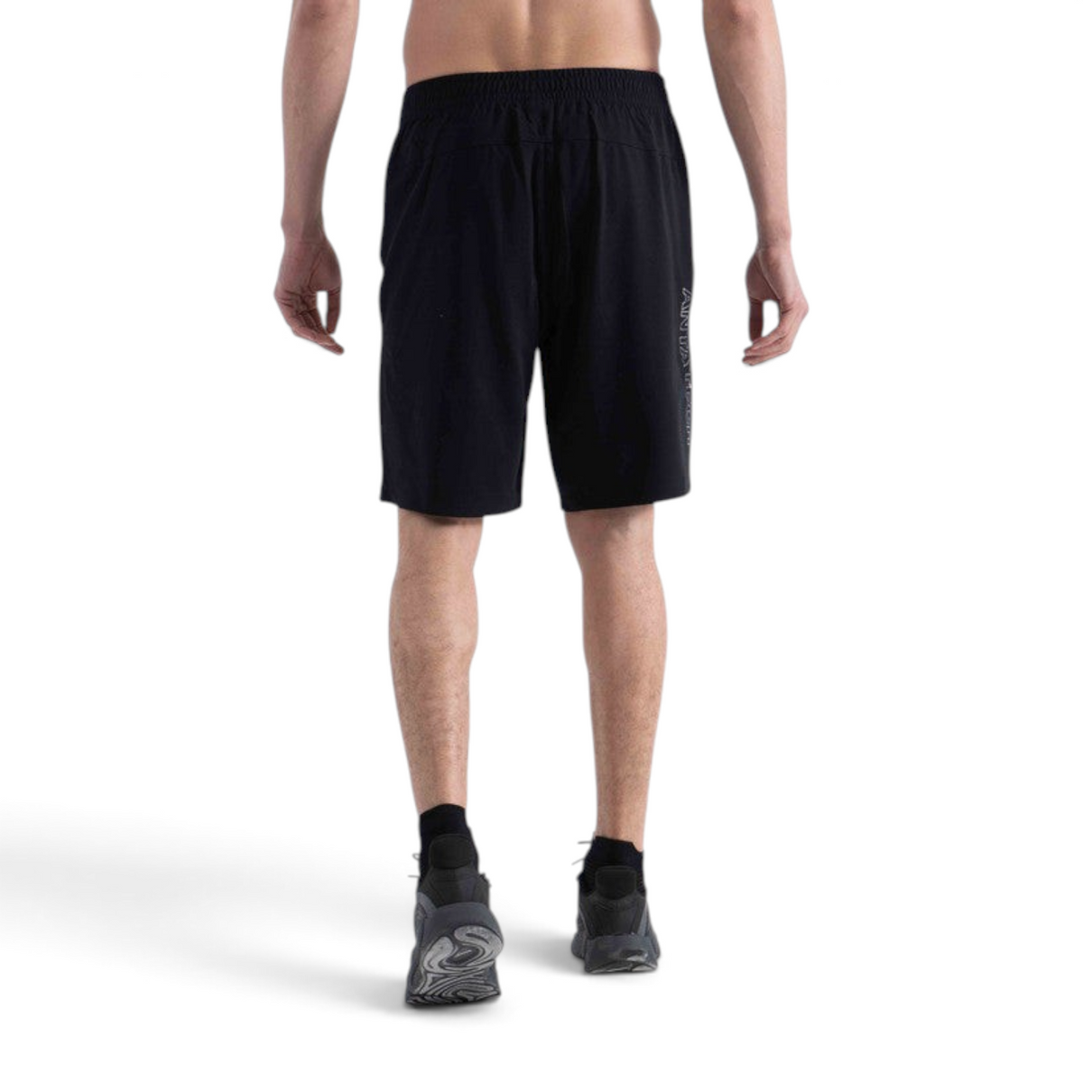 Back view of a man wearing black FRG knit half pants with a subtle logo detail on the leg