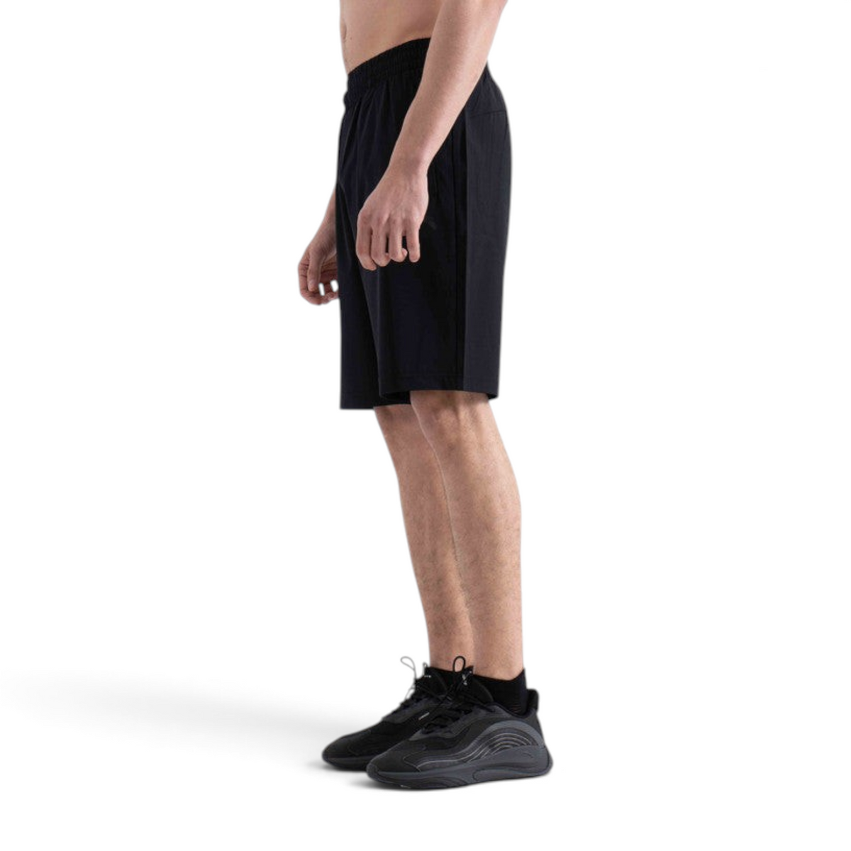 FRG black athletic shorts worn by a man in a side profile view, featuring a comfortable elastic waistband.