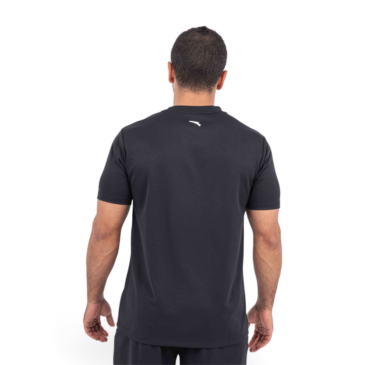 Back view of a man wearing a black FRG athletic t-shirt with a small white logo on the upper back