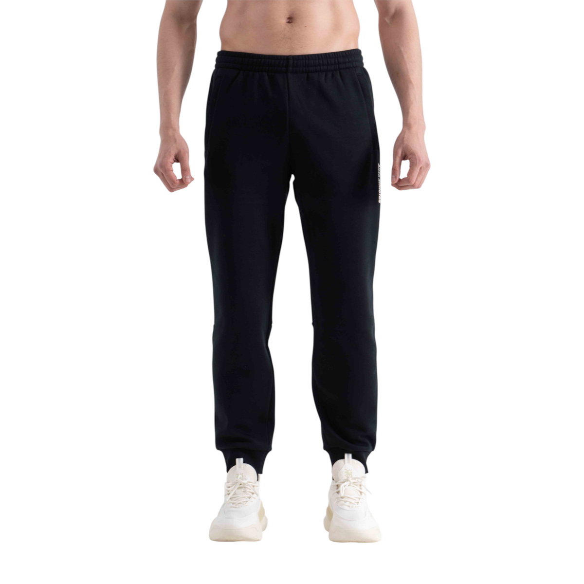 FRG black knit track pants with elasticated cuffs worn by a shirtless man against a white background