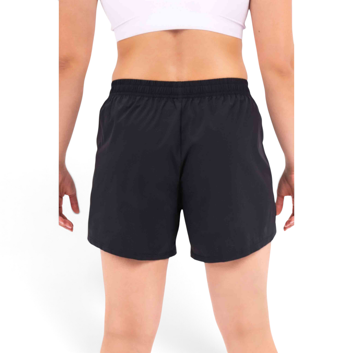 Back view of FRG black athletic shorts with an elastic waistband worn by a woman