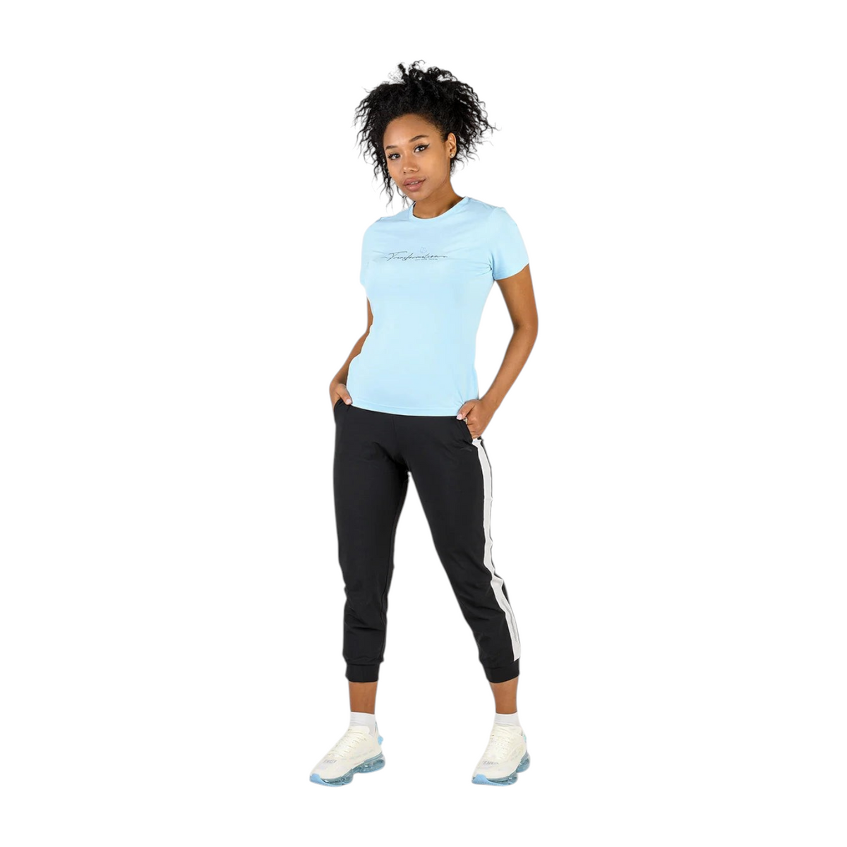 Model wearing a light blue FRG cross training t-shirt with black joggers and white sneakers