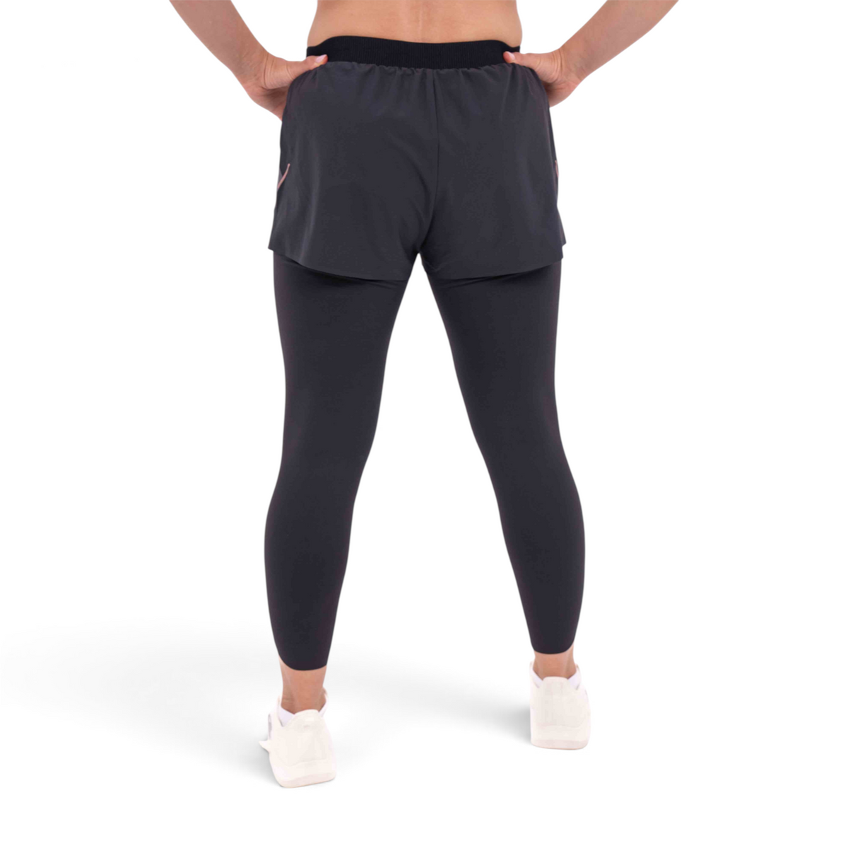 FRG slim fit black track pants with integrated shorts and leggings, back view on a model wearing white sneakers