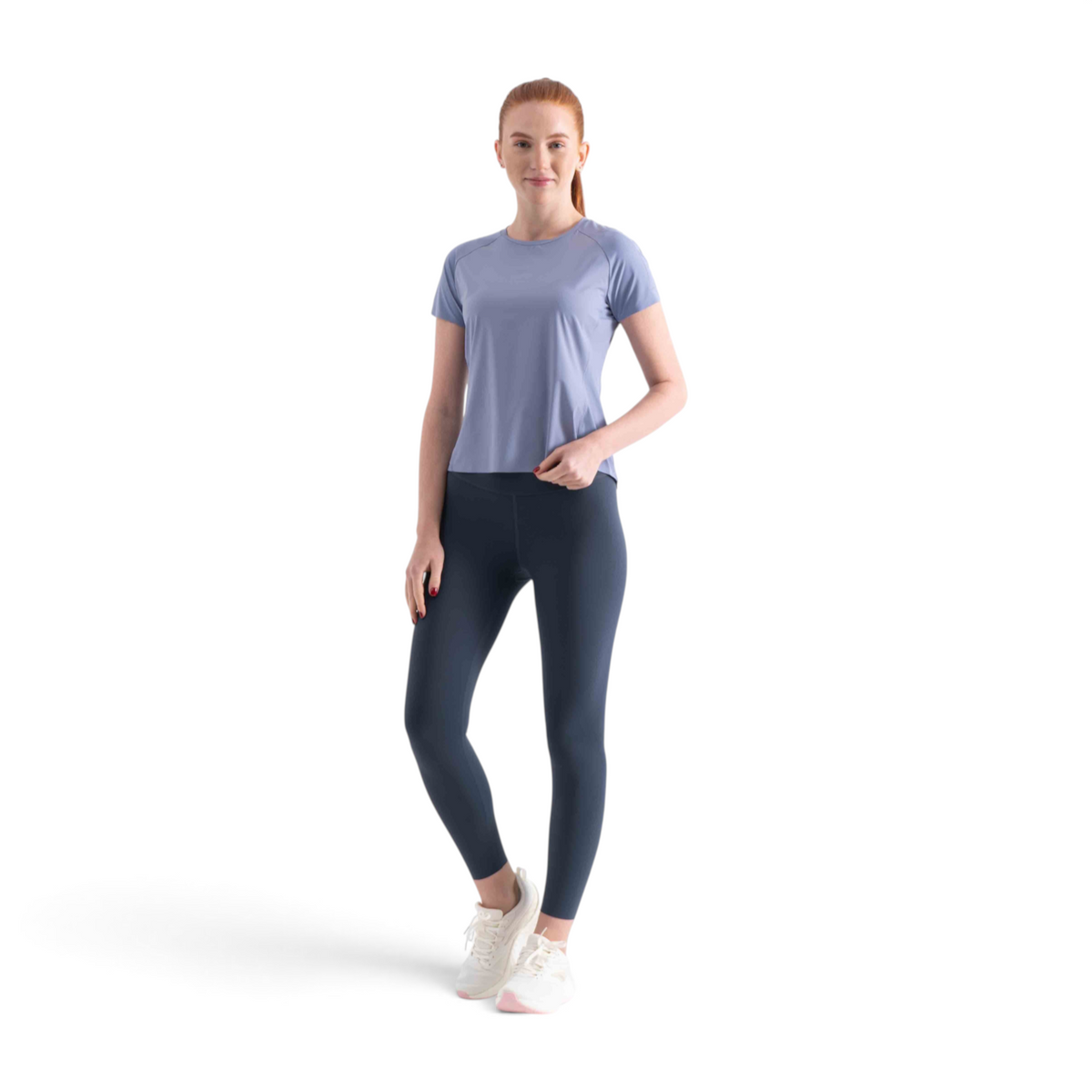 FRG SS TEE in light blue worn by a woman with dark leggings and white sneakers against a white background