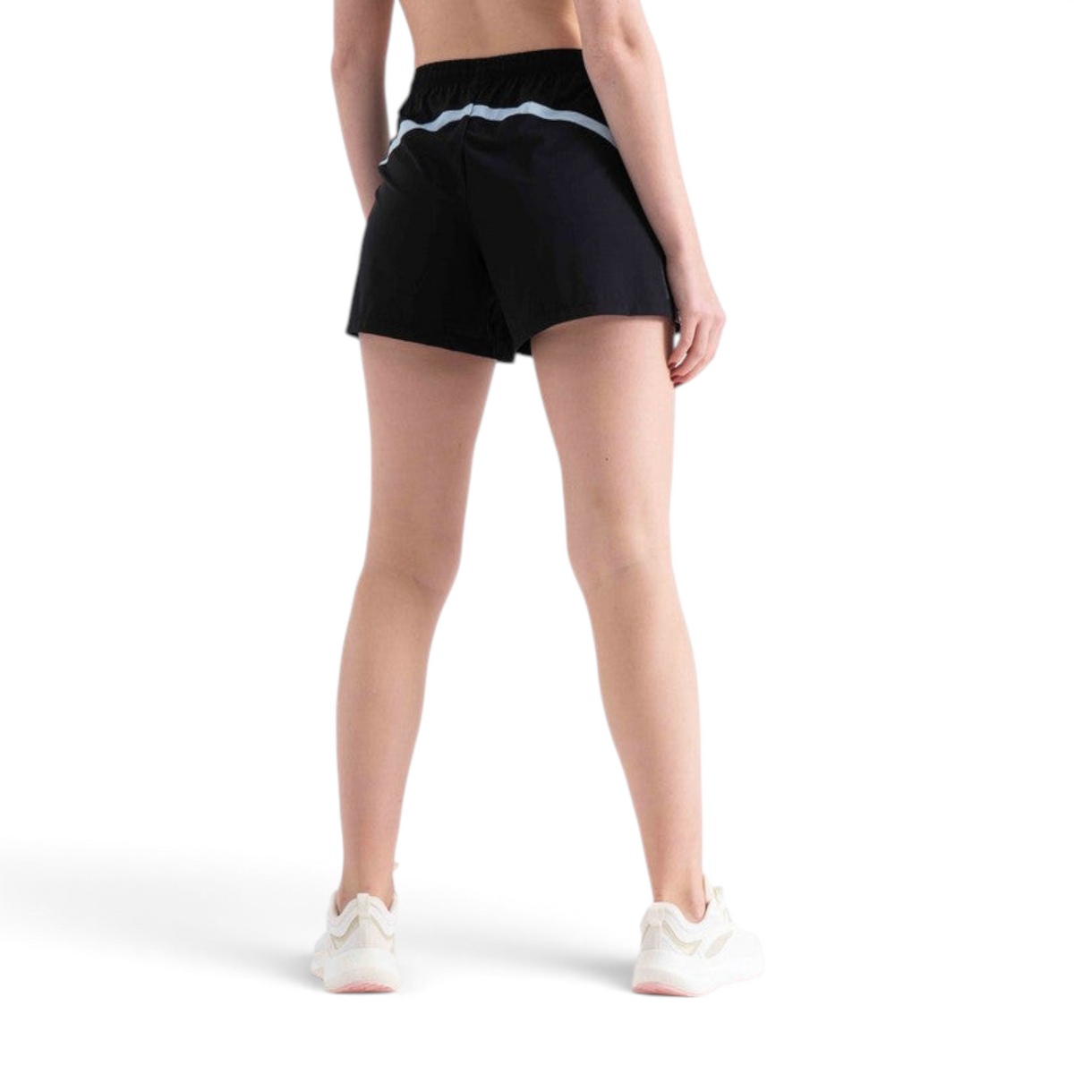 Back view of a woman wearing black FRG athletic shorts with a light blue reflective stripe on a white background
