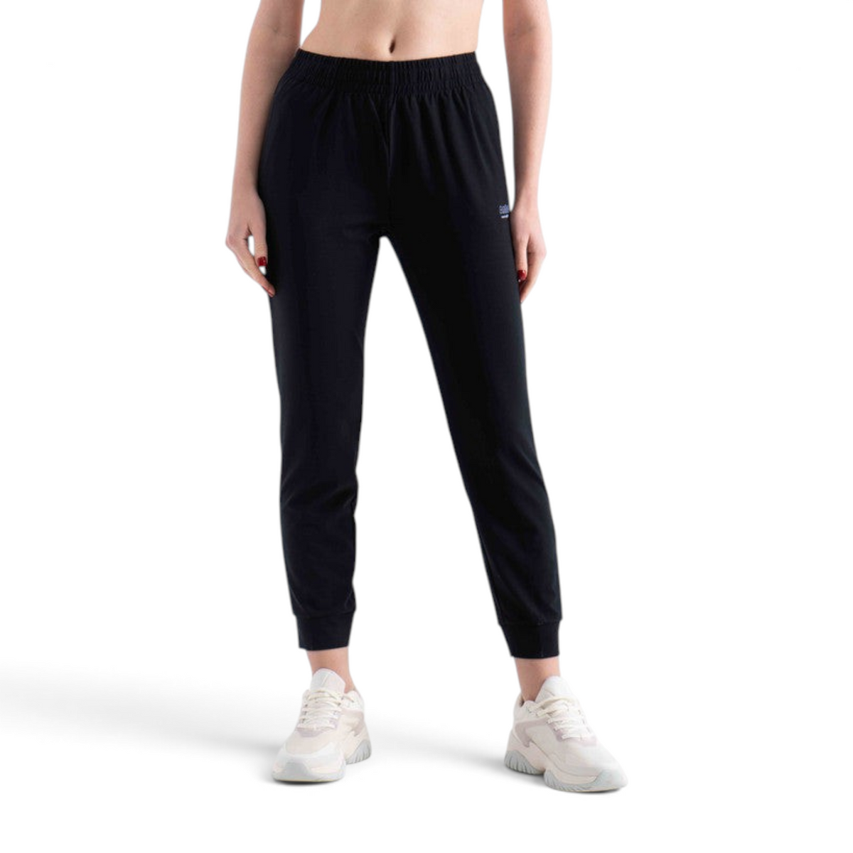 FRG black knit ankle pants with an elastic waistband and cuffed hems worn by a model with white sneakers