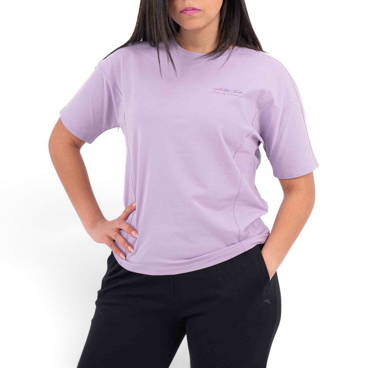 A woman wearing a FRG lavender short-sleeve t-shirt with a small chest logo and drop-shoulder fit