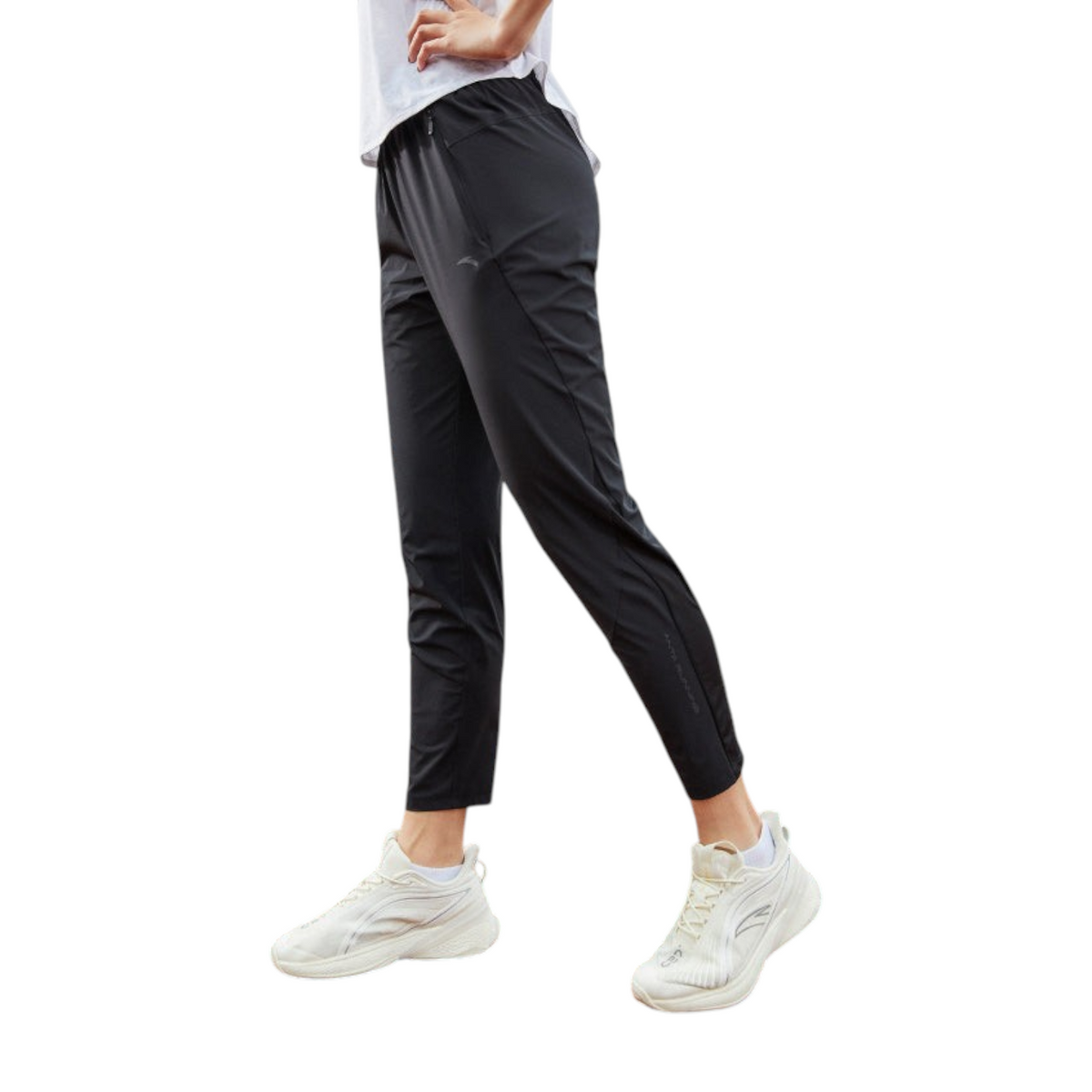 FRG ANTA black woven track pants on a runner wearing white sneakers on an outdoor track
