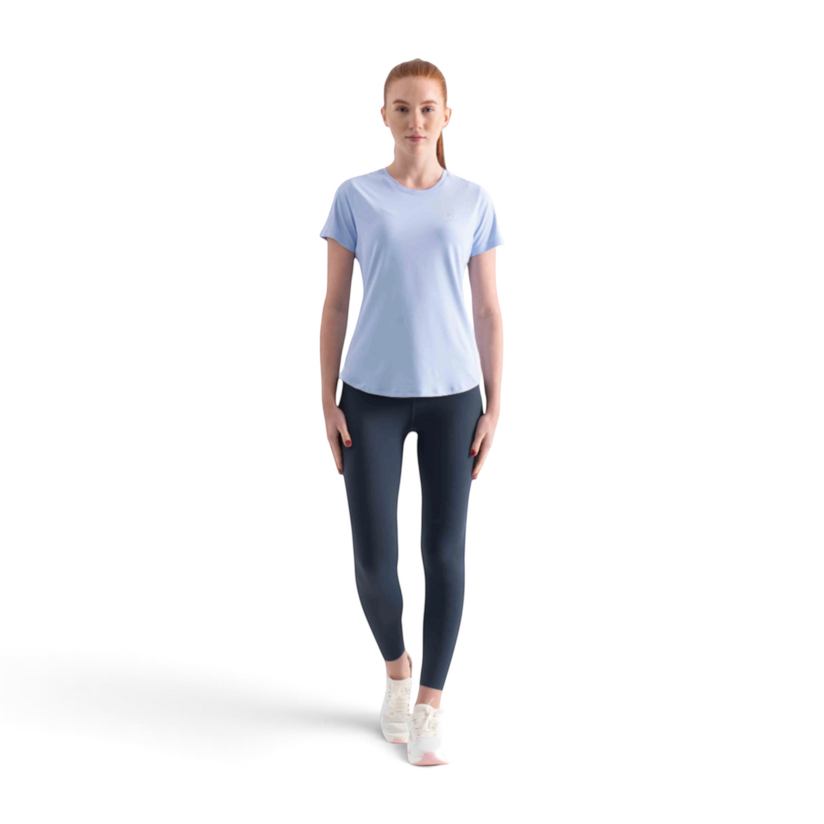 FRG SS TEE in light blue worn by a woman with dark leggings and white sneakers against a white background