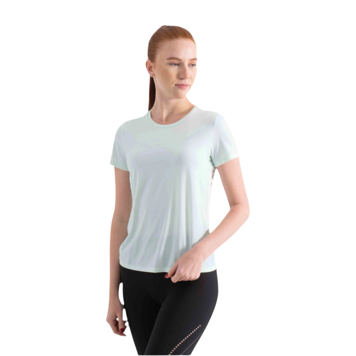 A woman wearing a light mint green FRG short sleeve t-shirt paired with black athletic leggings.