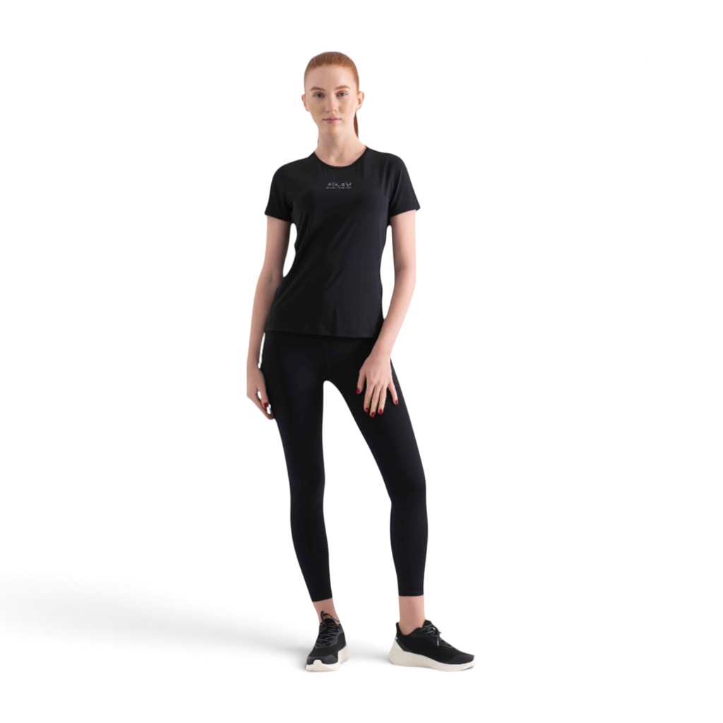 A woman wearing a black FRG short-sleeve athletic t-shirt and matching black leggings against a white background.